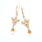 Gold filigree hand carved dangle earring with three swirls containing diamonds and faceted citrine dropout the bottom