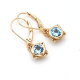 Handmade delicate gold earring with faceted sky blue topaz in center 