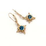 Tiny 14 karat gold star drop earrings with London blue topaz center